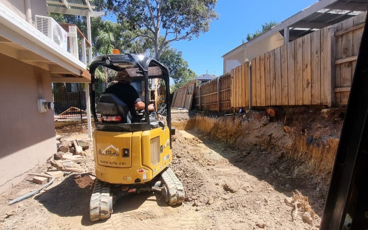 excavator cutting a level building pad on a residential site cut