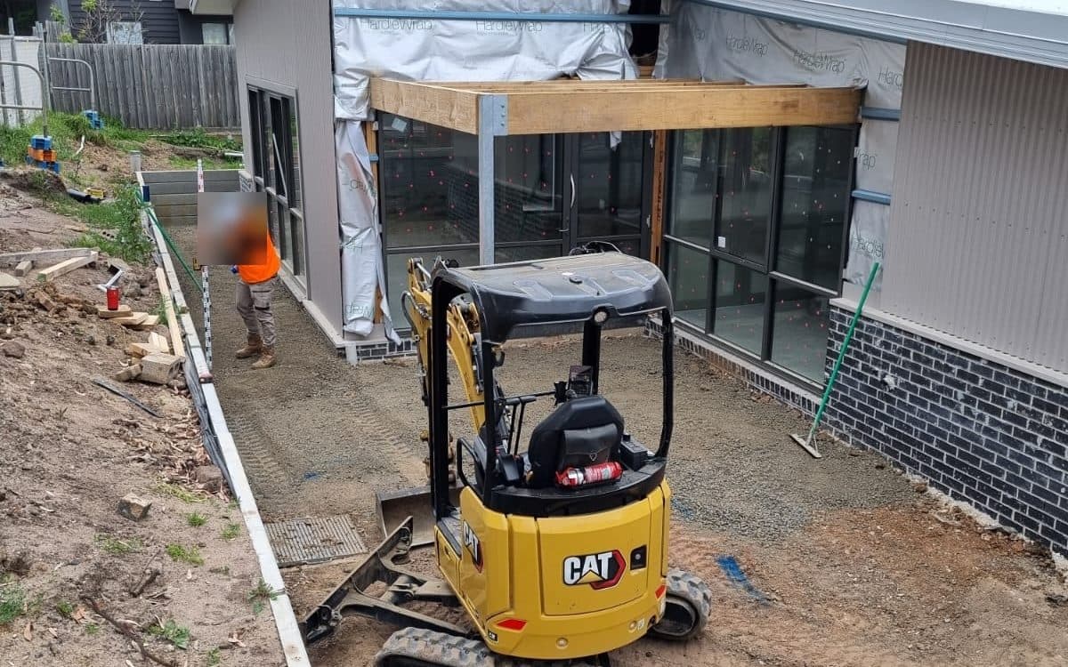 mini excavator working in narrow access alongside a new build