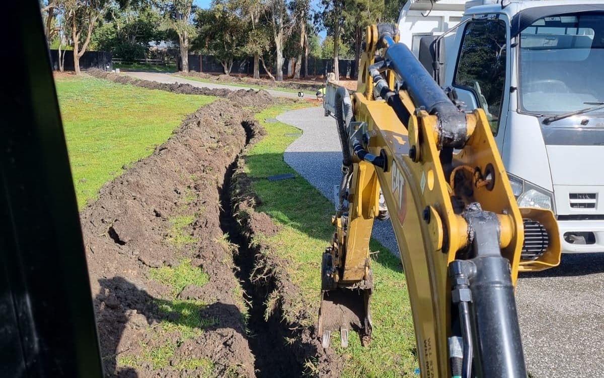 long trench run between a house and a garage on a residential block